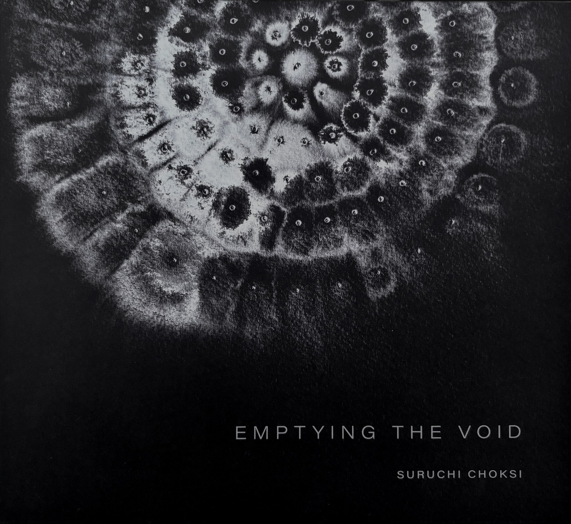 Cover of Emptying the Void — white ink blooms radiating on black cloth